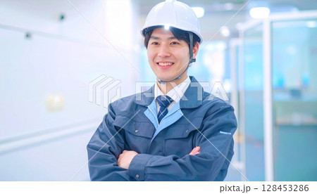 ヘルメットを着用して腕組みをする作業服の男性 128453286