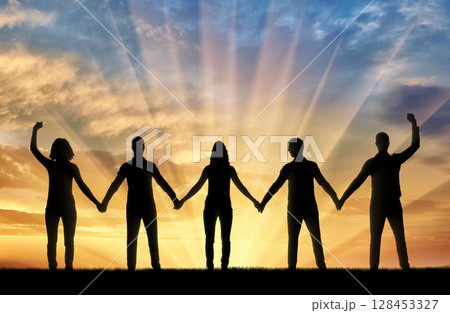 Silhouette of a group of happy people of five people holding hands at sunset Silhouette of a group of happy people of five people holding hands at sunset 128453327