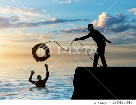 A silhouette of a man throws a lifeline to another man who is drowning in the water 128453340