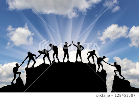 Silhouette of climbers who climbed to the top of the mountain thanks to mutual assistance Silhouette of climbers who climbed to the top of the mountain thanks to mutual assistance 128453387