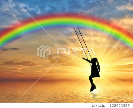 Silhouette, little girl child on a swing rainbow over the sea. Silhouette, little girl child on a swing rainbow over the sea. 128453547