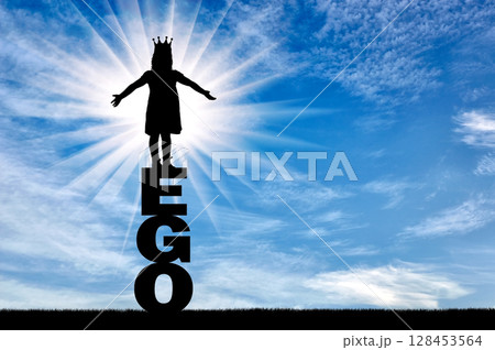 Little girl with a crown on her head standing on the word of the ego 128453564