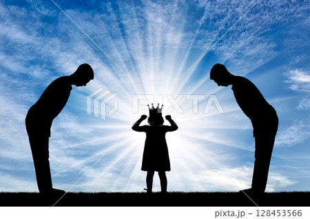 Selfish little girl with a crown on her head and two servants worship her 128453566