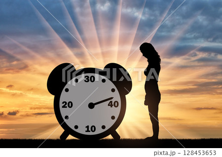 Sad woman standing at the clock hand which shows almost 40 years Sad woman standing at the clock hand which shows almost 40 years 128453653