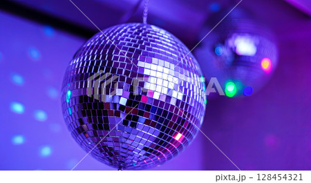 A shimmering disco ball reflects vibrant blue hues in a mesmerizing dance of light and color 128454321