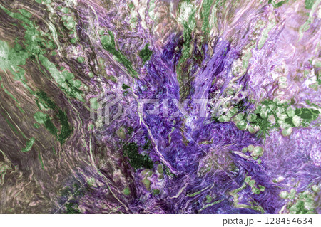 Bright mineral texture of stone with swirling patterns of green and purple hues. Natural geological formation with intricate details for background or backdrop 128454634