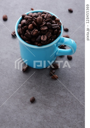 コーヒーカップと、深煎りしたコーヒー豆 コーヒーカップと、深煎りしたコーヒー豆 128455369