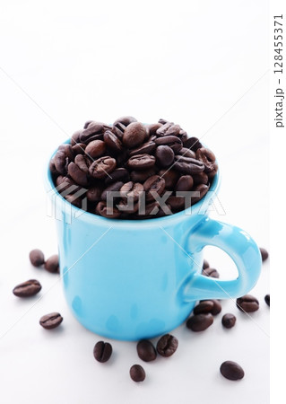 コーヒーカップと、深煎りしたコーヒー豆 コーヒーカップと、深煎りしたコーヒー豆 128455371