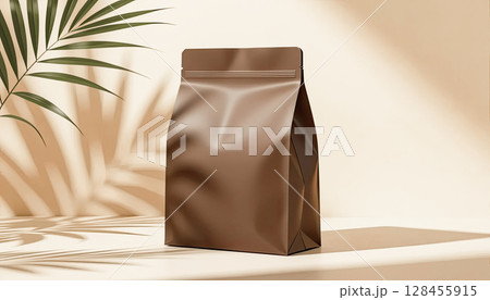 Generic bag of coffee beans with empty space for label on beige background with shadows from palm leaves Generic bag of coffee beans with empty space for label on beige background with shadows from palm leaves 128455915