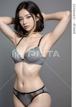 グレーのブラとレースのパンティを着た女性が両腕を上げるポーズ 128456222