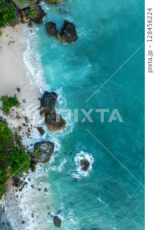 Top Aerial view of impossible Beach in Bali, Indonesia. Empty paradise beach, blue sea waves in Bali island, Indonesia 128456224