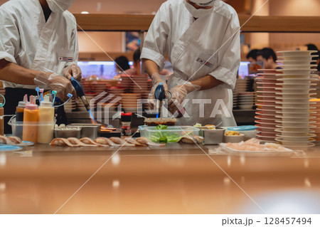 Professional Sushi Chefs Preparing Fresh Dishes in a Restaurant Kitchen Professional Sushi Chefs Preparing Fresh Dishes in a Restaurant Kitchen 128457494