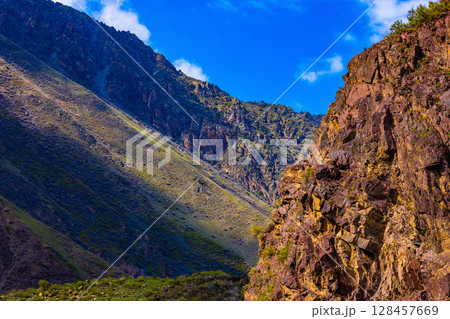 Rocky cliff in majestic mountain landscape at sunny summer day in Kyrgyzstan 128457669