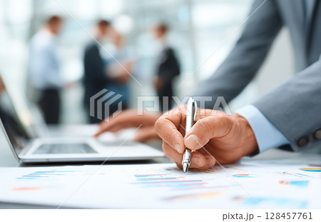 ペンを片手に、会社の将来について話し合うビジネスチーム 128457761