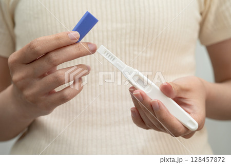 Asian holding pregnancy test for female of ovulation day, fetus, maternity, childbirth, birth control. Asian holding pregnancy test for female of ovulation day, fetus, maternity, childbirth, birth control. 128457872