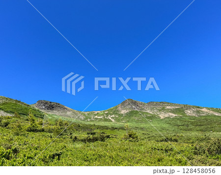 Green mountain landscape under a clear blue sky. Green mountain landscape under a clear blue sky. 128458056