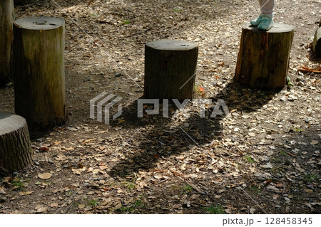 公園の切り株と遊ぶ子供の影 128458345