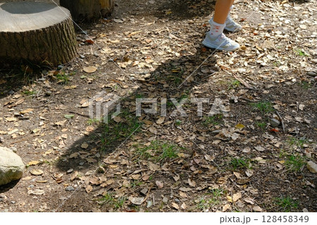 公園の切り株と遊ぶ子供の影 128458349