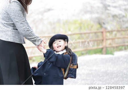 桜と入園式を迎えた3歳の女の子と母親 128458397
