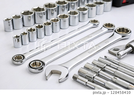 Socket wrench set with various chrome tools on white surface. Socket wrench set with various chrome tools on white surface. 128458410