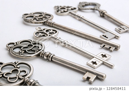 Antique decorative keys in row on neutral background. Antique decorative keys in row on neutral background. 128458411