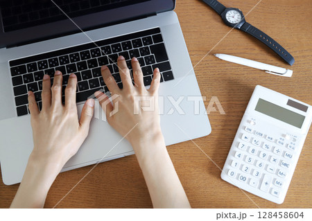 パソコンを使って仕事をする手元 128458604