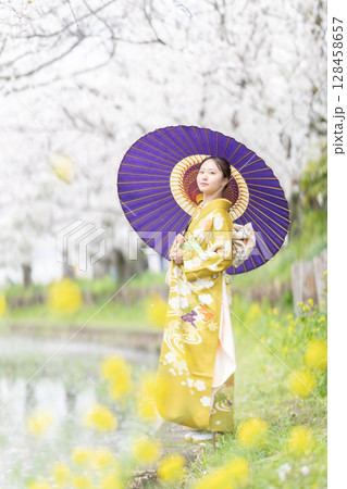 満開の桜を振袖で歩く若い女性 満開の桜を振袖で歩く若い女性 128458657