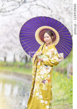 満開の桜を振袖で歩く若い女性 満開の桜を振袖で歩く若い女性 128458660
