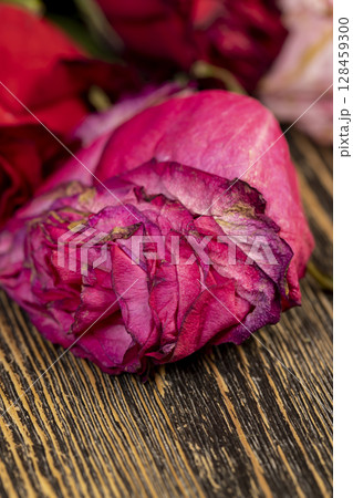 colorful red dry roses in a bouquet, a dry bouquet of red roses on the table, closeup 128459300