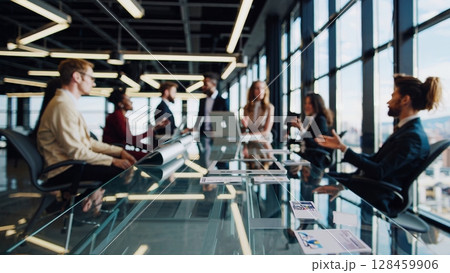 Business partners discussing during a meeting in a modern office, sitting at a glass table, analyzing financial charts and statistics, collaborating and working together on a new project 128459906
