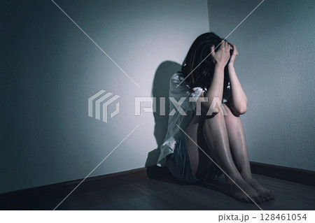 暗い部屋で恐怖に怯える女性 128461054