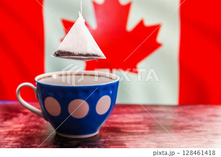 Tea bag over cup with canadian flag in background 128461418