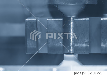 Closeup scene the operation of wire EDM machine control by CNC program in the blue tone. Closeup scene the operation of wire EDM machine control by CNC program in the blue tone. 128462206