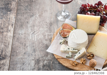 Board of different cheeses with nuts, figs and grapes Board of different cheeses with nuts, figs and grapes 128462308