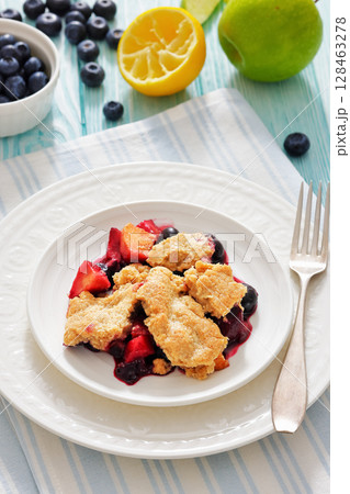 apple blueberry strawberry crumble on white plate 128463278