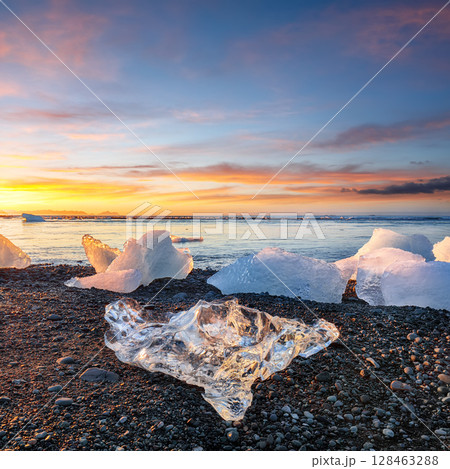 Ramarkable pieces of the iceberg sparkle on famous Diamond Beach at  Jokulsarlon lagoon during sunset. 128463288