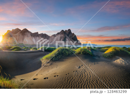 Impressive sunset with gorgeous black sand dunes on Stokksnes cape in Iceland. 128463299