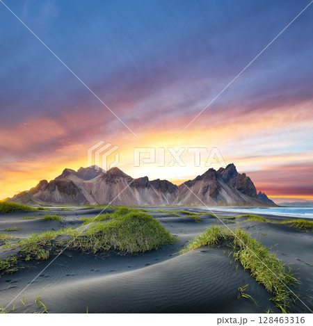 Remarkable sunset with gorgeous black sand dunes on Stokksnes cape in Iceland. 128463316