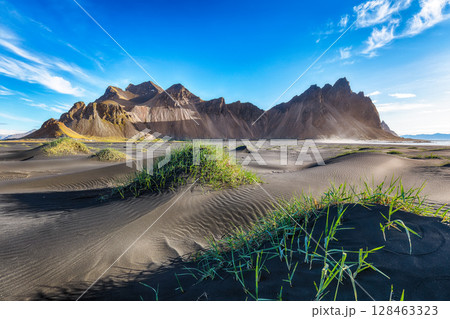 Amazing sunny day and gorgeous black sand dunes on Stokksnes cape in Iceland. 128463323