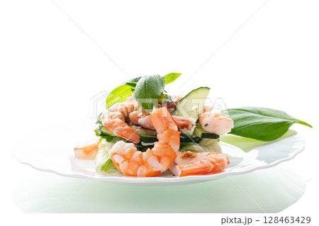 Fresh vegetable salad with shrimps and cucumbers on a white background Fresh vegetable salad with shrimps and cucumbers on a white background 128463429
