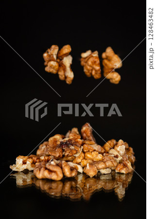 delicious peeled walnuts on a black background delicious peeled walnuts on a black background 128463482