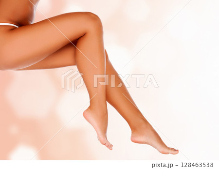 Long smooth female legs against an abstract background with circles and copyspace 128463538
