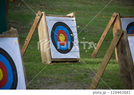 Colorful Archery Targets with Arrows Outdoors in a Grassy Area 128463881