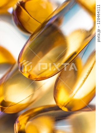 Close-up of shiny yellow vitamin capsules, healthy concept Close-up of shiny yellow vitamin capsules, healthy concept 128464111