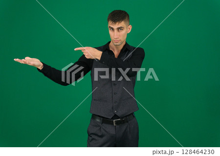 Photo of young man happy positive smile look indicate thumb empty space recommend advert isolated over grey color background Photo of young man happy positive smile look indicate thumb empty space recommend advert isolated over grey color background 128464230