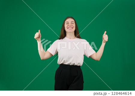 Hispanic woman standing over isolated background doing happy thumbs up gesture with hand. approving expression looking at the camera showing success. Hispanic woman standing over isolated background doing happy thumbs up gesture with hand. approving expression looking at the camera showing success. 128464614