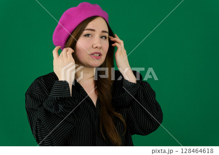 Studio shot of pensive french girl looking up. Charming young woman in beret thinking about something on pink background. Studio shot of pensive french girl looking up. Charming young woman in beret thinking about something on pink background. 128464618