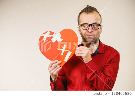 Thinking adult man holding broken heart 128465680