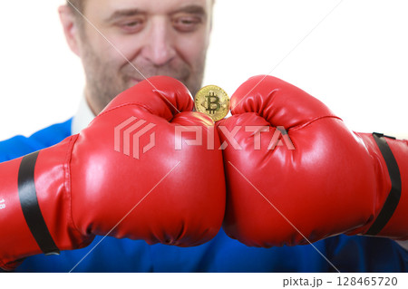 Man in boxing gloves holding bitcoin 128465720