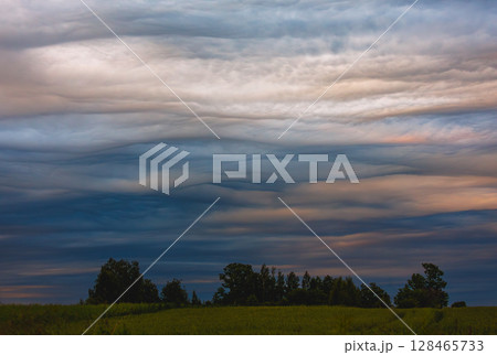 Photograph of a dramatic isolated Asperitas cumulus thunderstorm cloud 128465733